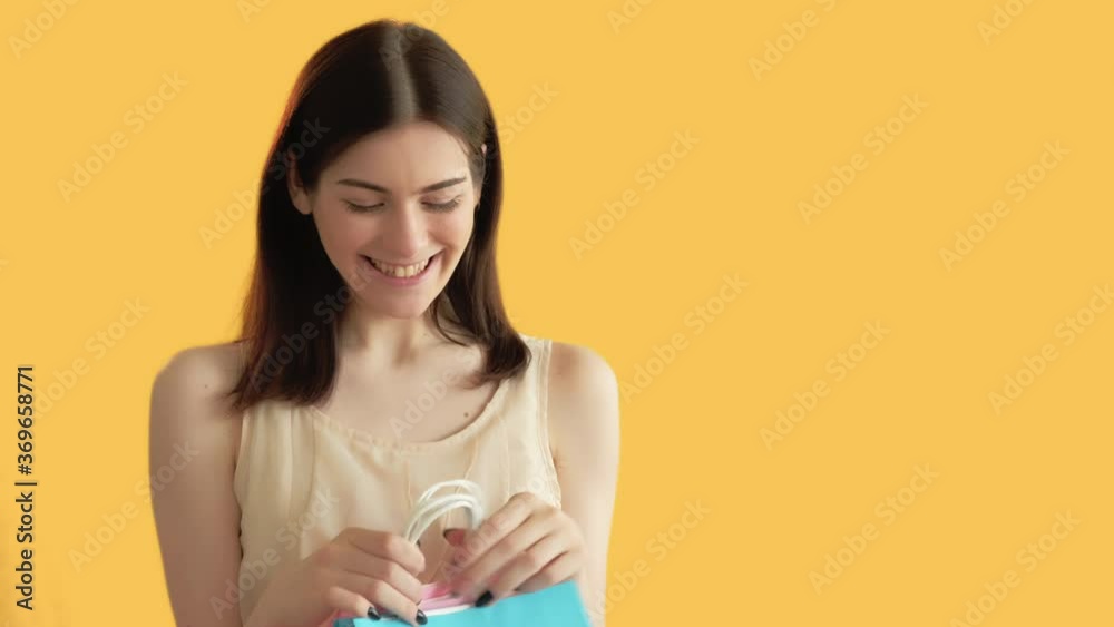 Happy shopping. Online sale. Surprised woman with paper bags. Isolated on orange free space. Shopaholic lifestyle. Black friday Happy shopping. Online sale. Surprised woman with paper bags. Isolated on orange free space. Shopaholic lifestyle. Black friday