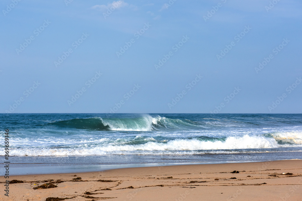The huge waves crashing into ston island against the blue sky and horizon at summer sea shore. The huge waves crashing into ston island against the blue sky and horizon at summer sea shore.