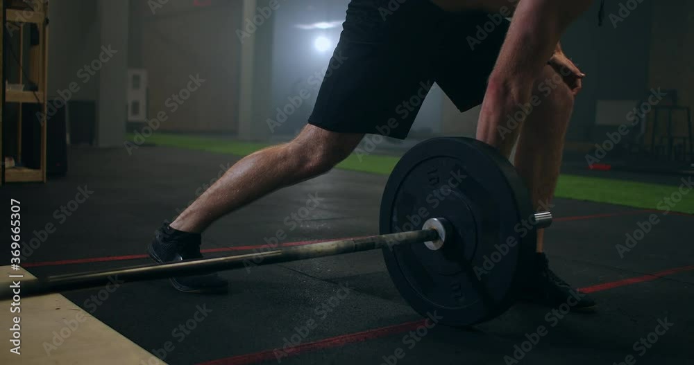 Slow motion: Man doing Single-Arm Landmine Squat-to-Press exercise. Young man lifting barbell with light weights at gym Slow motion: Man doing Single-Arm Landmine Squat-to-Press exercise. Young man lifting barbell with light weights at gym