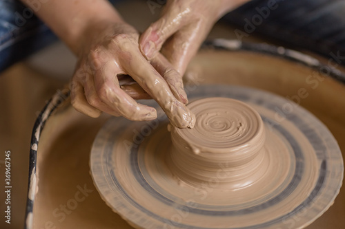 Closeup shot of female ceramic artist works on pottery wheel in studio space, Creative People Handcrafted 