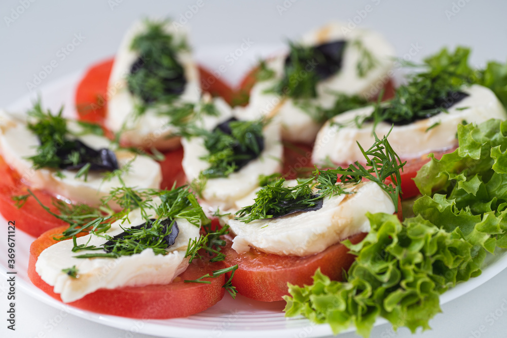 Caprese salad is a low-calorie cold Italian snack. The dish contains 3 ingredients: tomatoes, mozzarella and basil. Caprese salad is a low-calorie cold Italian snack. The dish contains 3 ingredients: tomatoes, mozzarella and basil.