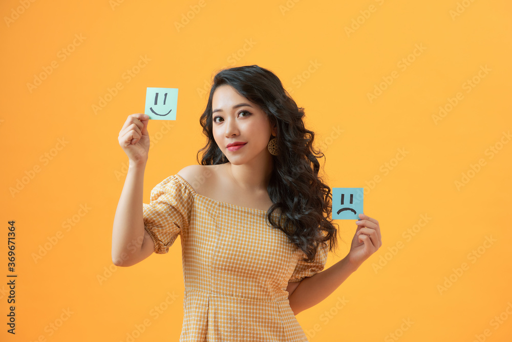 Photo of funny lady holding paper emoticons good and bad mood picking positive emotions Photo of funny lady holding paper emoticons good and bad mood picking positive emotions