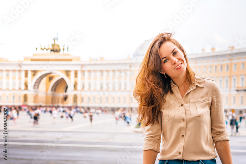 A beautiful woman with long hair visits the tourist city of Saint Petersburg while staying at the main attraction on the Palace square in the center © KseniaJoyg