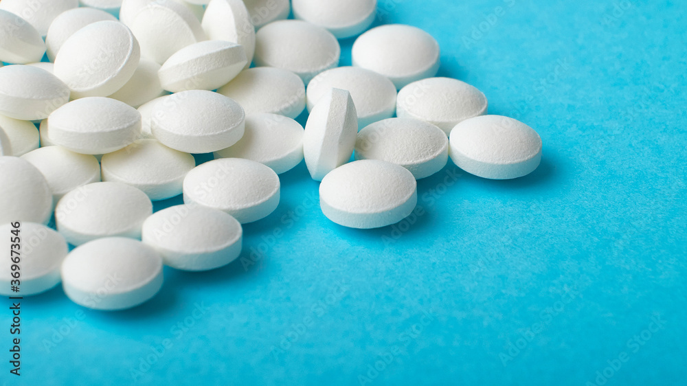 various white tablets macro on a blue background various white tablets macro on a blue background