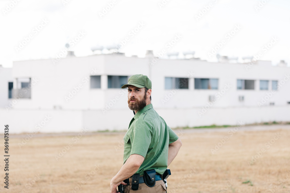 white man with security-watching beard controlling population areas and manufacturing