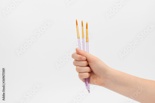 Paint brushes in a female hand.