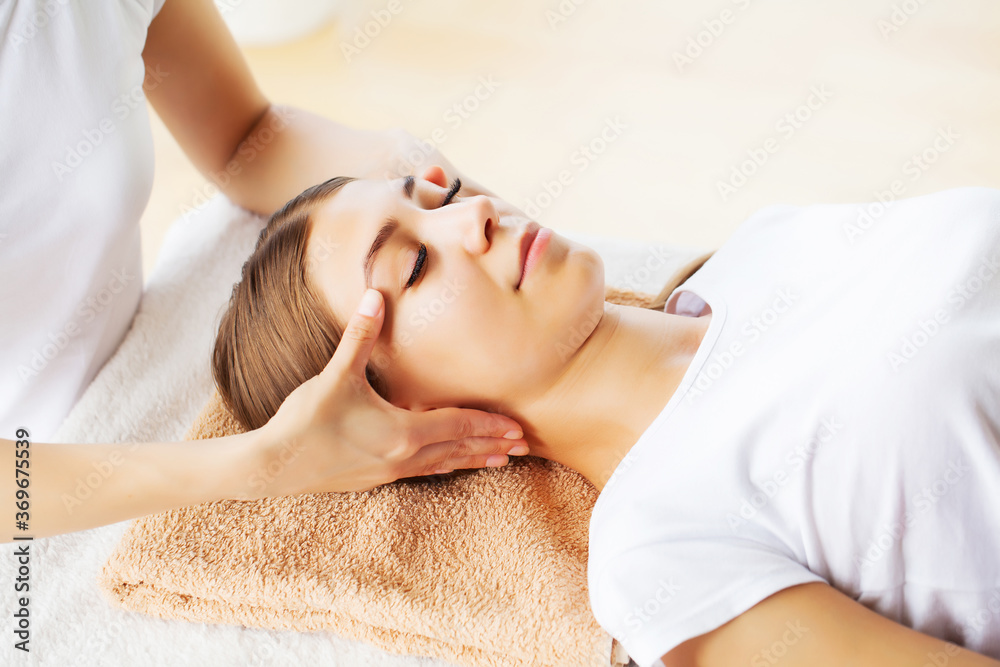 Young beautiful girl having face massage relaxing in spa salon. Young beautiful girl having face massage relaxing in spa salon.