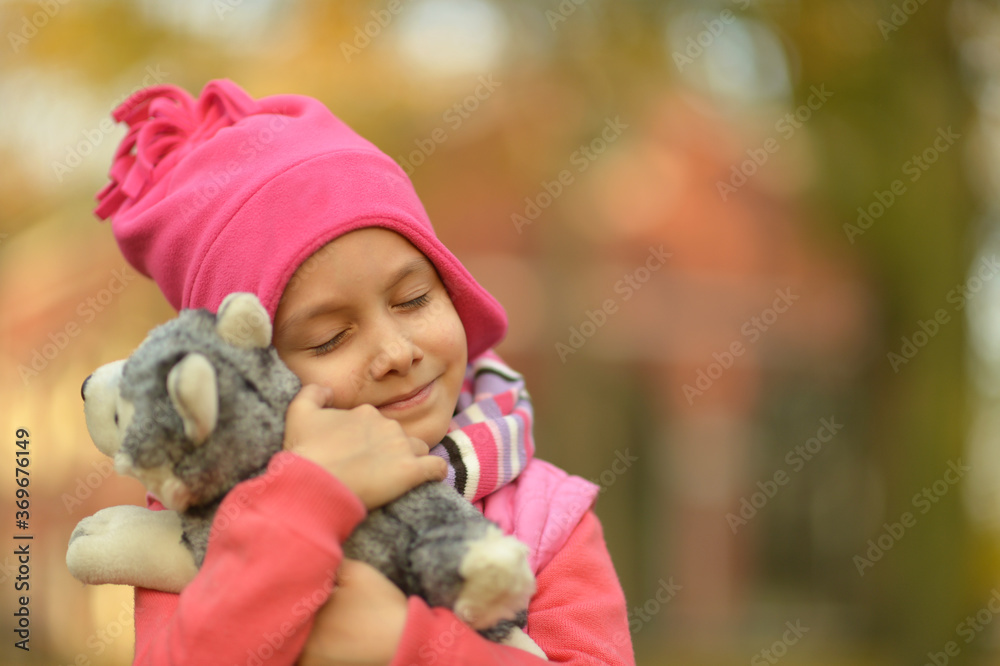Cute little girl in an autumn park with toy Cute little girl in an autumn park with toy