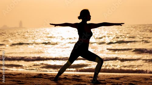 young woman doing yoga on the beach
