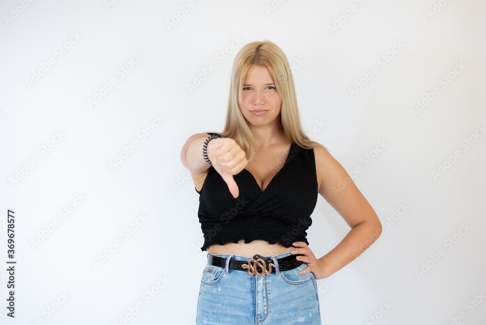 Beautiful blonde girl in black shirt with finger down gesture Beautiful blonde girl in black shirt with finger down gesture