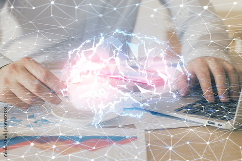 Businessman with computer background with brain theme hologram. Concept of brainstorm. Multi exposure.