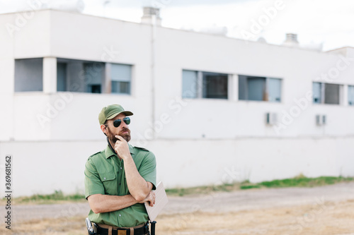 white man with security-watching beard controlling population areas and manufacturing