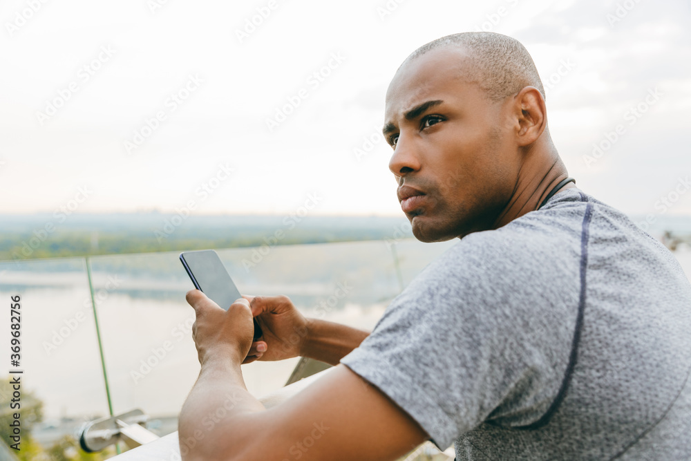 Sporty young african man typing on a smart phone
