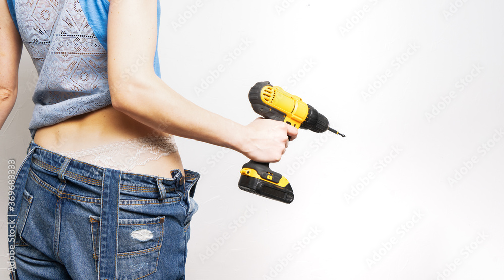 Women at work: a girl holds a yellow screwdriver in her hands.