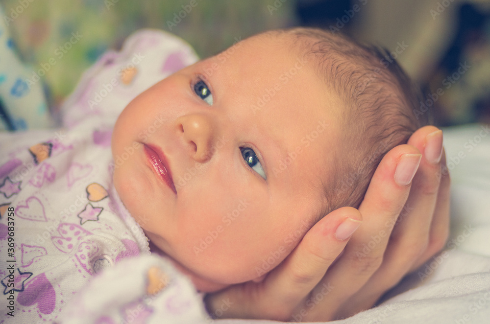 A small head of a newborn baby is placed in the mother's hand A small head of a newborn baby is placed in the mother's hand
