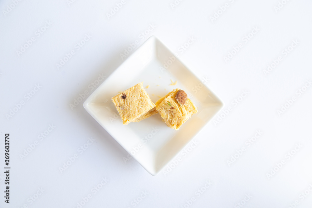 Soan papdi or patisa is a popular Indian dessert, it is cut in cube-shaped or served as flakes, and has a crisp and flaky texture.