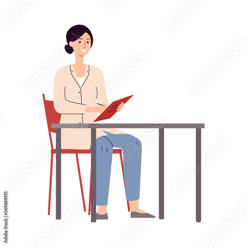 Female doctor sitting behind desk and writing in notebook