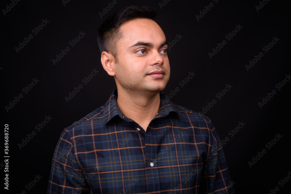 Portrait of young handsome Indian hipster man