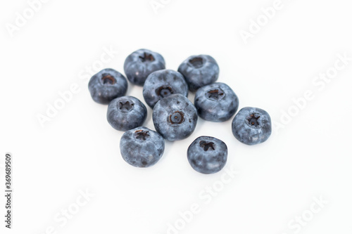  Blueberries on a white background. And also in a glass with a yellow tube. On a gray background.