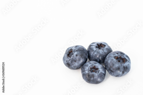  Blueberries on a white background. And also in a glass with a yellow tube. On a gray background.