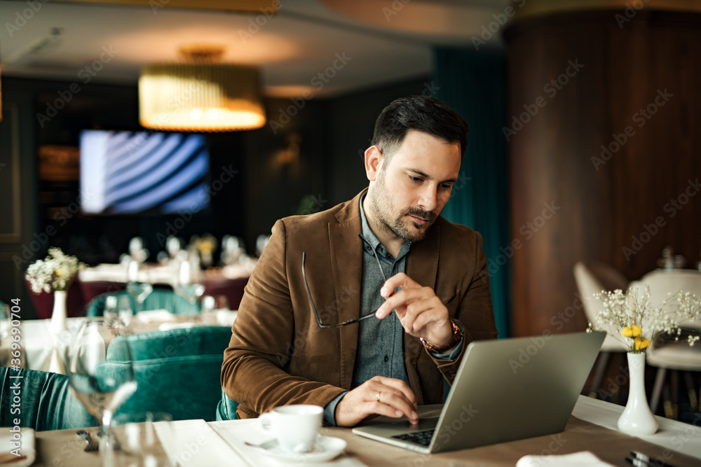 Portrait of a angry businessman looking at laptop in the restaurant.