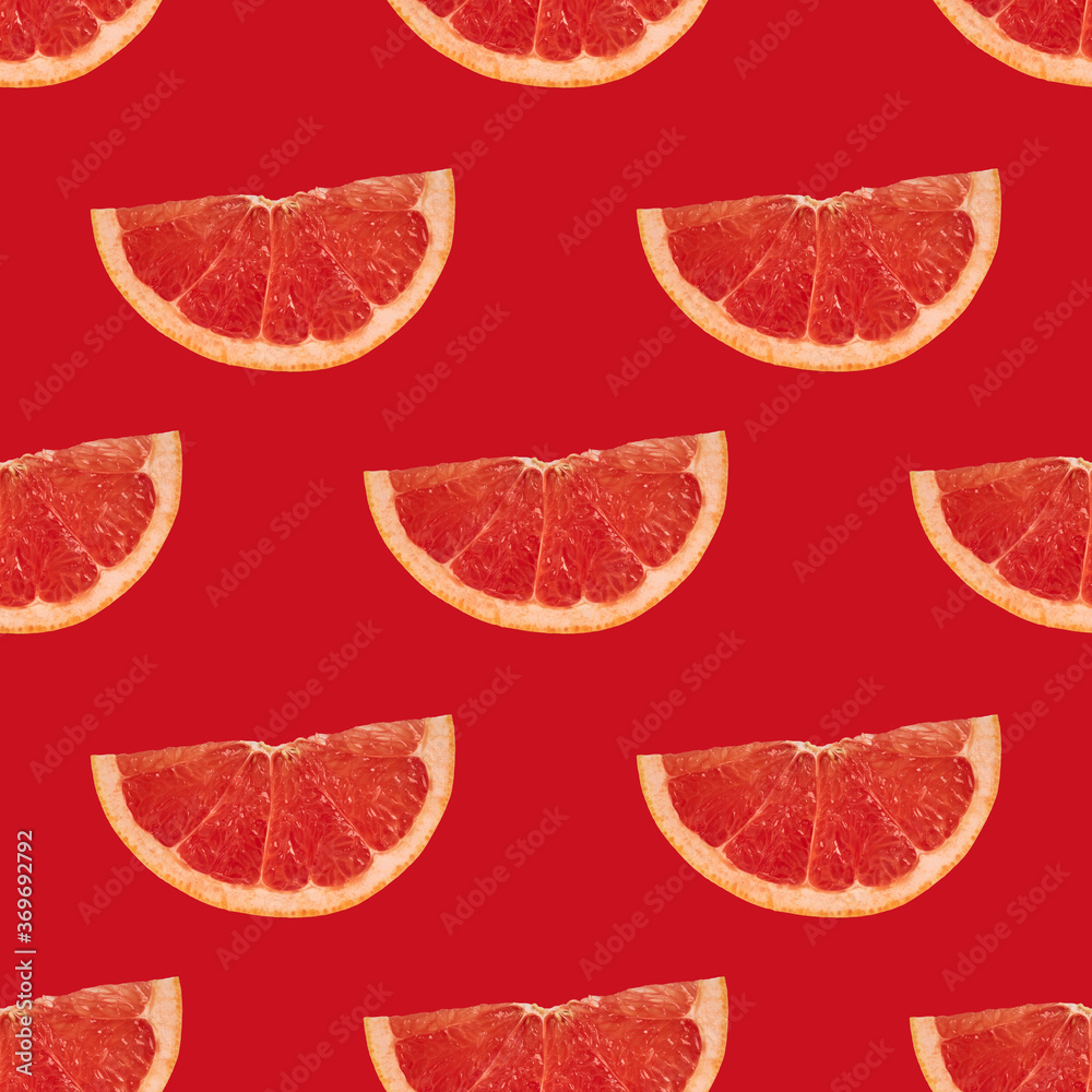 Slices of ripe grapefruit on a bright red background. Geometric seamless pattern