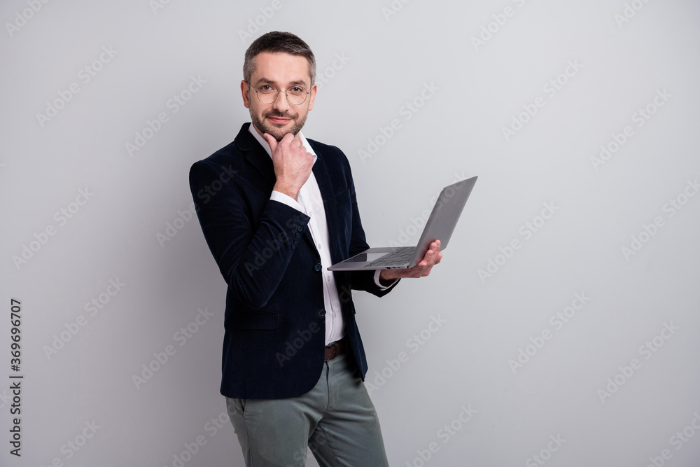Portrait of his he nice attractive cheery content mature man holding in hands laptop preparing finance analysis data presentation money report isolated over light gray pastel color background