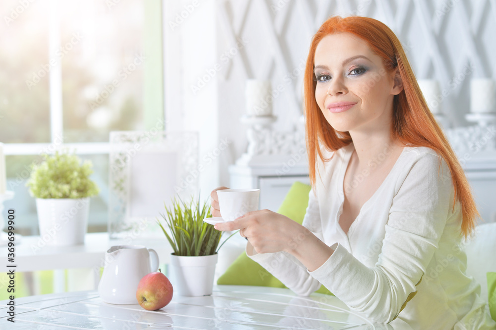 Young beautiful woman drinking coffee at home