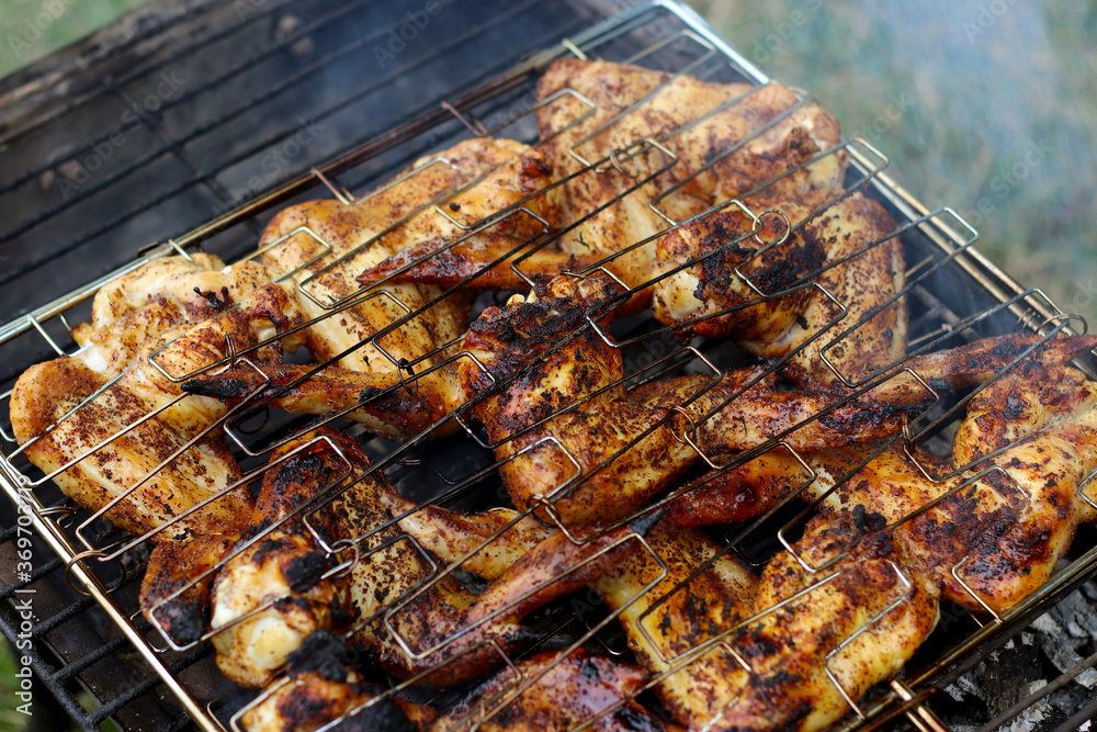Chicken wings grilling on a summer barbecue. BBQ background.