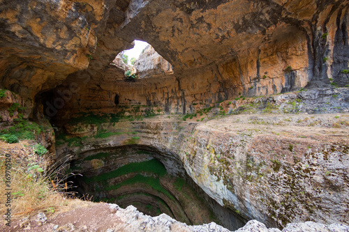 Baatara gorge waterfall in Lebanon. Balaa Sinkhole caves and formations covered with green plants. Natural stone bridges photo