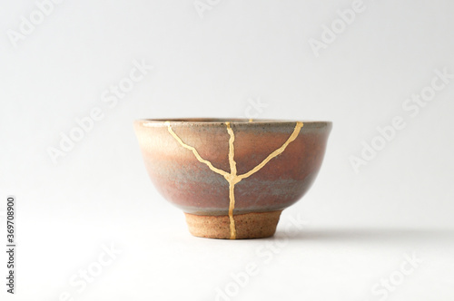 Japanese kintsugi ceramic sake cup, restored with real gold. Antique pottery kintsukuroi.
