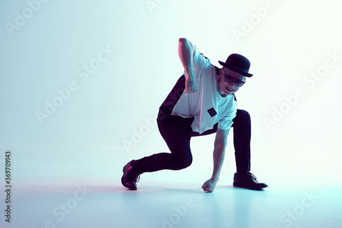 Young breakdancer guy in hat and sunglasses dance in neon light. Dance school poster. Battle competition announcement