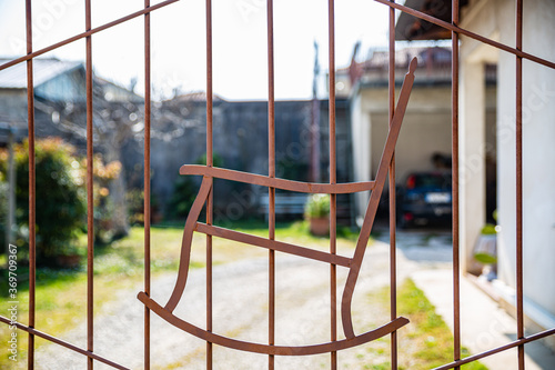 Close up view of metallic gate with the image of a rocking chair.