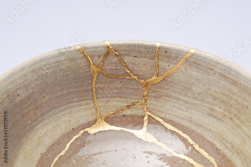 Japanese kintsugi ceramic chawan bowl restored with real gold. Antique pottery kintsukuroi. photo