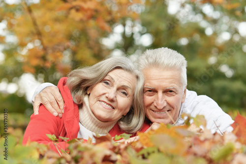 Happy senior couple lying on autumn leaves