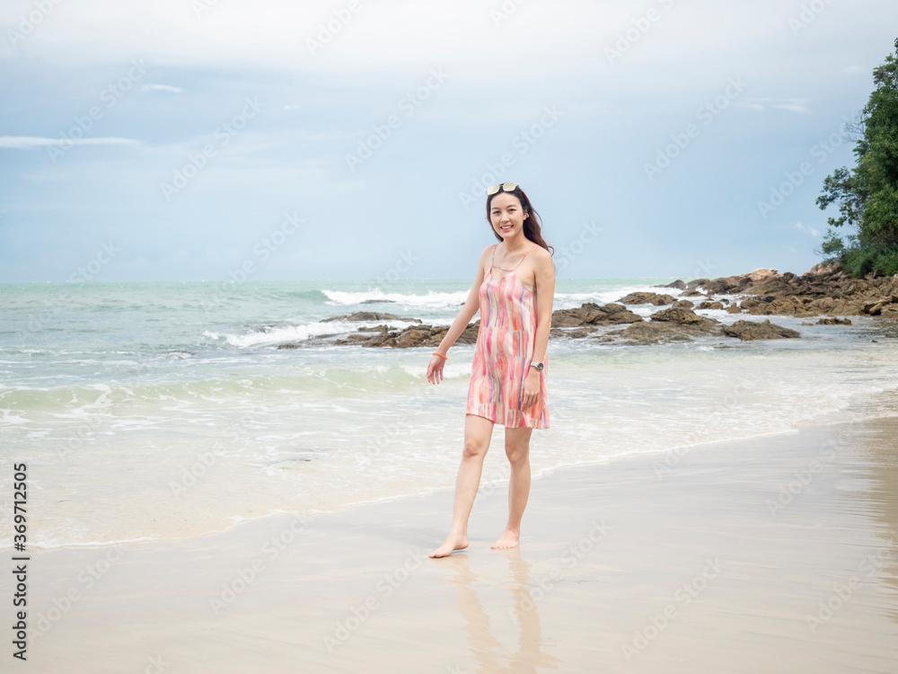 asian woman in pink dress walking on beautiful beach at Samed, Thailand. asian woman in pink dress walking on beautiful beach at Samed, Thailand.