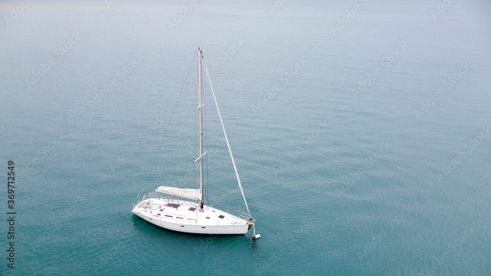 Aerial shot of beautiful blue lagoon at hot summer day with sailing boat anchored. Aerial shot of beautiful blue lagoon at hot summer day with sailing boat anchored.