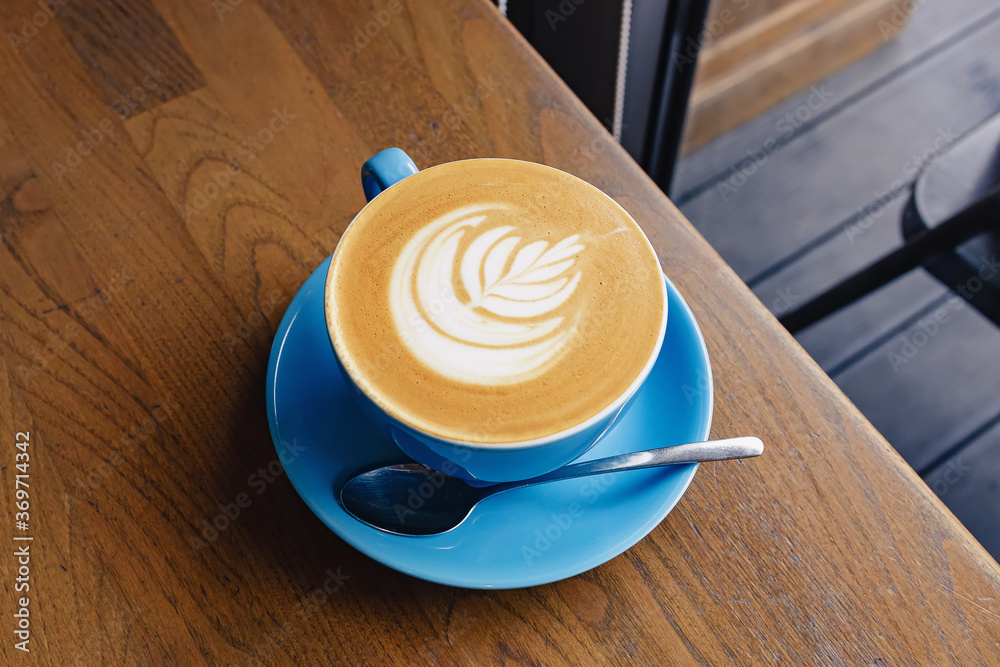 Blue cup of fresh cappuccino with latte art Blue cup of fresh cappuccino with latte art