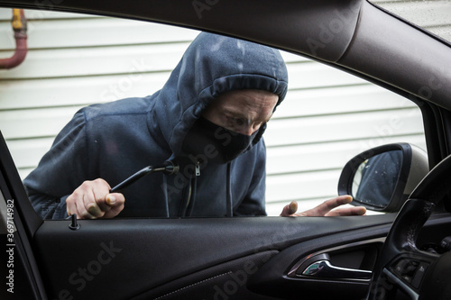 The criminal is trying to hack the car. Car thief.