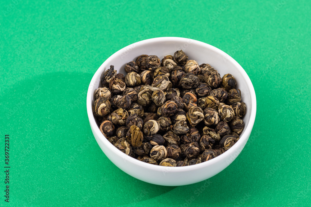 loose tea in a saucer and poured nearby on a contrasting background loose tea in a saucer and poured nearby on a contrasting background