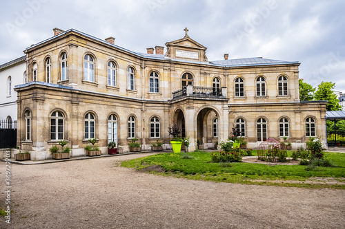 Eugene-Napoleon building (1856) in little green Paris Public Park Jardin Eugene-Napoleon. Paris, France. [Inscription: Eugene Napoleon House built in 1856 by his majesty Empress].