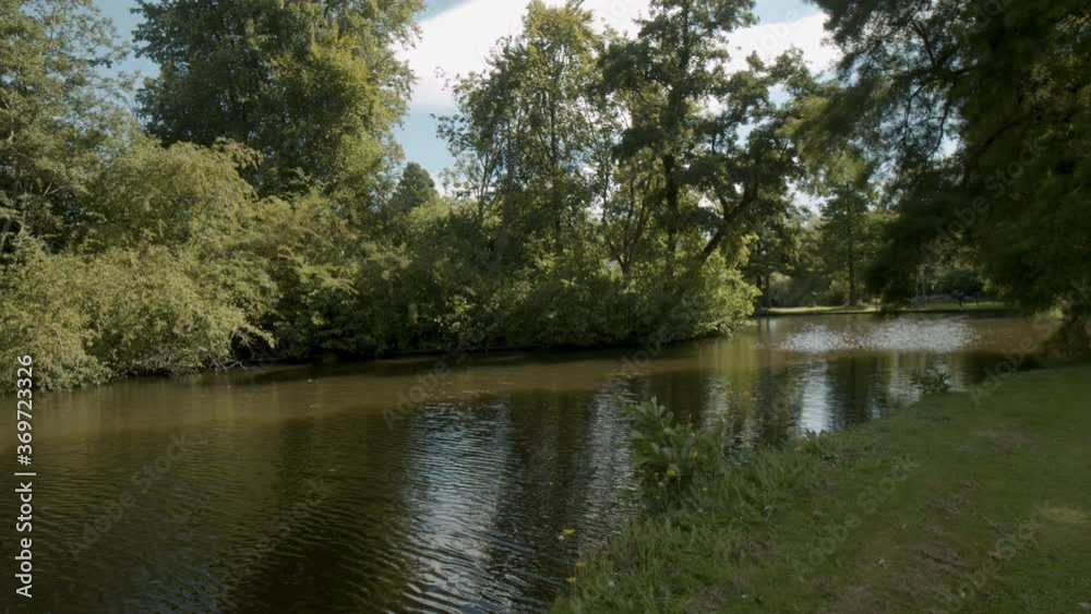 Small river flowing through beautiful park in summer Small river flowing through beautiful park in summer