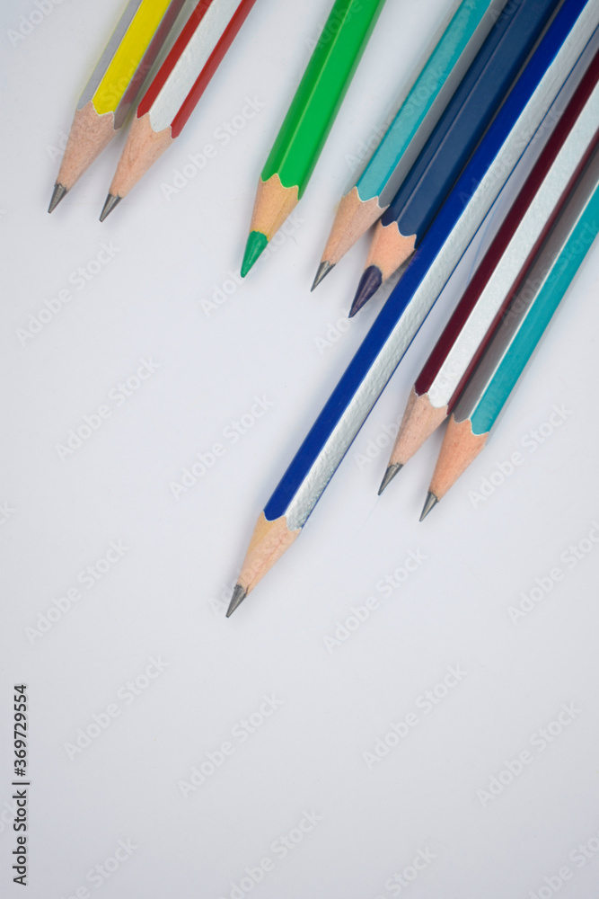 Different colored wood pencil crayons placed on top of a white background Different colored wood pencil crayons placed on top of a white background