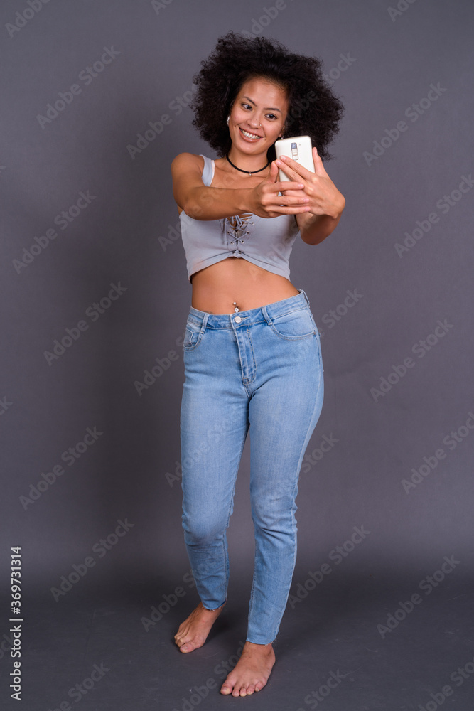 Happy young beautiful African woman with Afro hair taking selfie Happy young beautiful African woman with Afro hair taking selfie