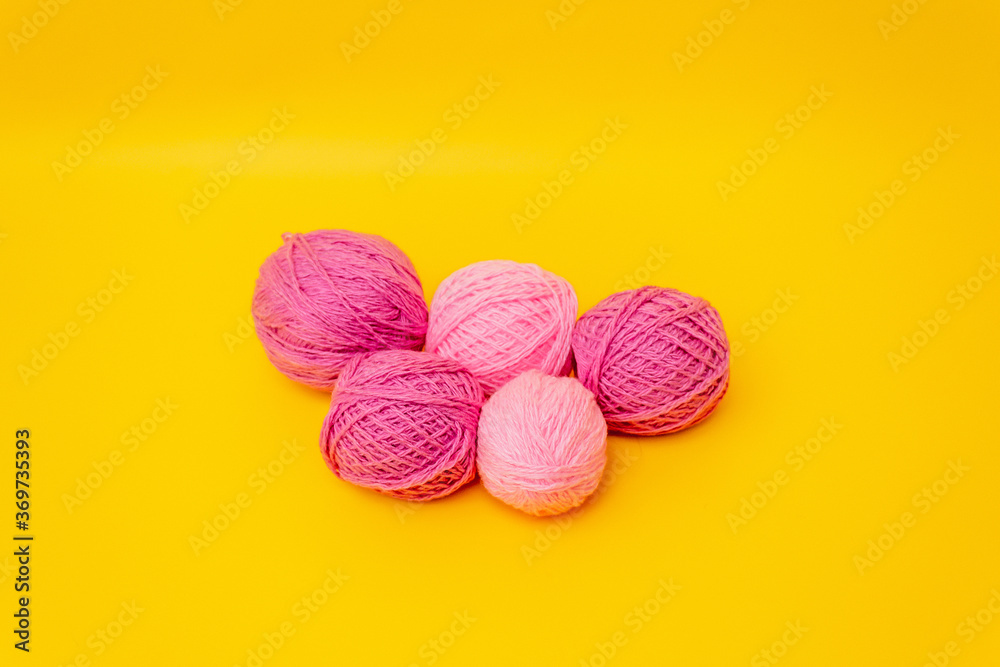 lilac, pink balls of wool lie on a yellow background lilac, pink balls of wool lie on a yellow background