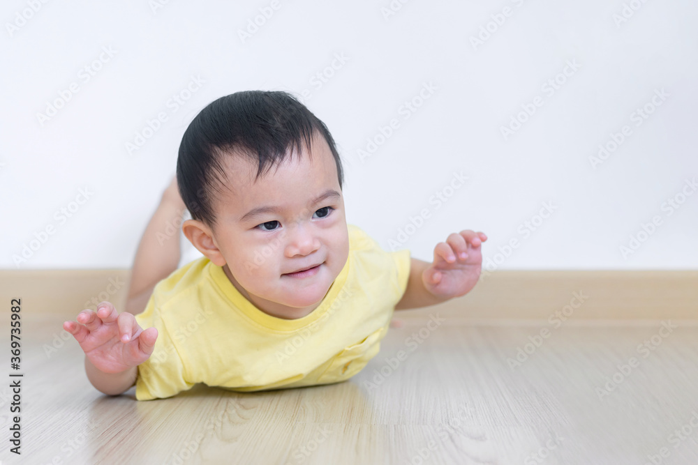 Happy Asian baby boy lying on the ground while balancing his body acting like flying in living room. Happy Asian baby boy lying on the ground while balancing his body acting like flying in living room.