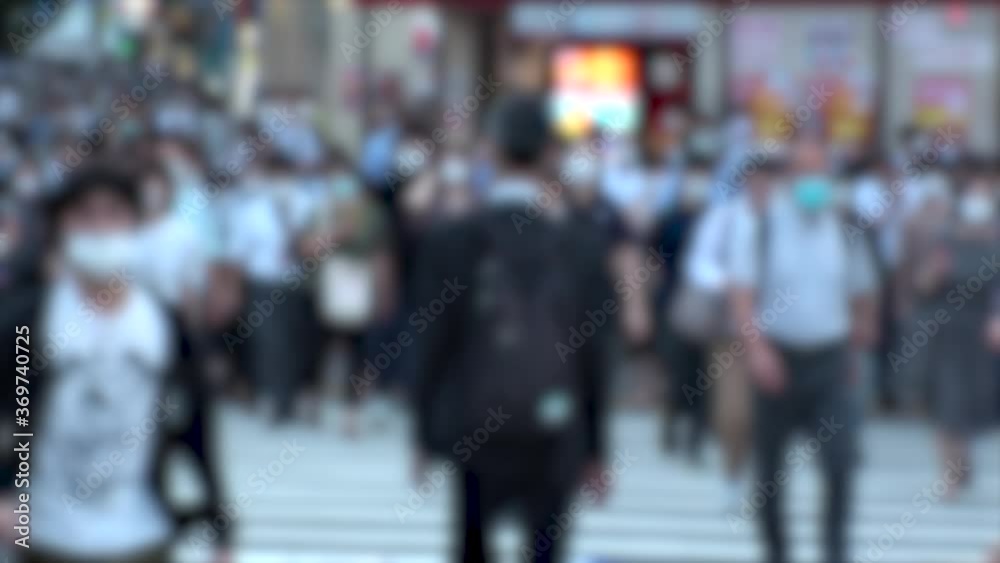 TOKYO, JAPAN - JUL 2020 : Crowd of people at the street near Shinjuku station in rush hour. Commuters wearing surgical mask to protect from Coronavirus (COVID-19) in hot summer season. Blurred shot. TOKYO, JAPAN - JUL 2020 : Crowd of people at the street near Shinjuku station in rush hour. Commuters wearing surgical mask to protect from Coronavirus (COVID-19) in hot summer season. Blurred shot.