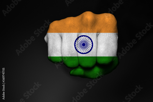 Obraz na płótnie Low key picture of a fist painted in colors of Indian flag on a black background w salonie