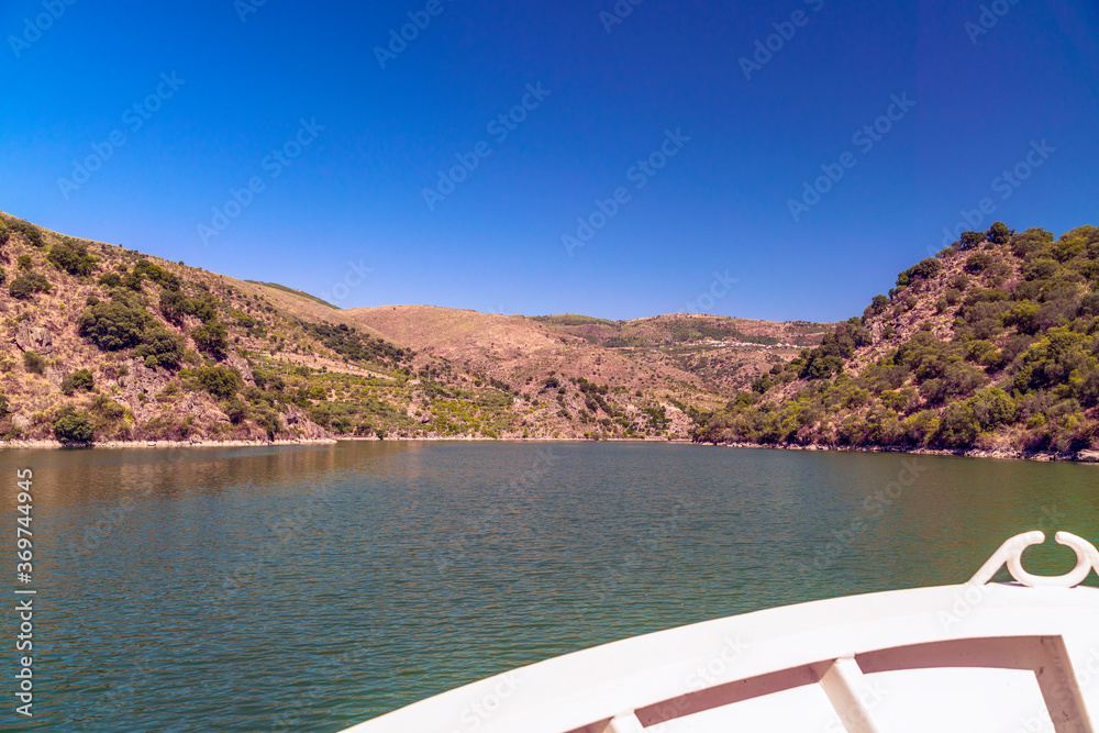 bow of the boat sailing on the Douro River in the Arribes del Duero between the rocky mountains in summer.
