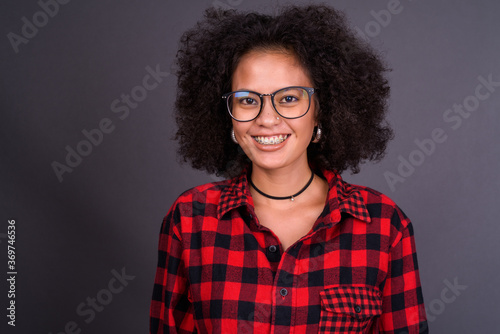 Happy young beautiful African hipster woman with eyeglasses